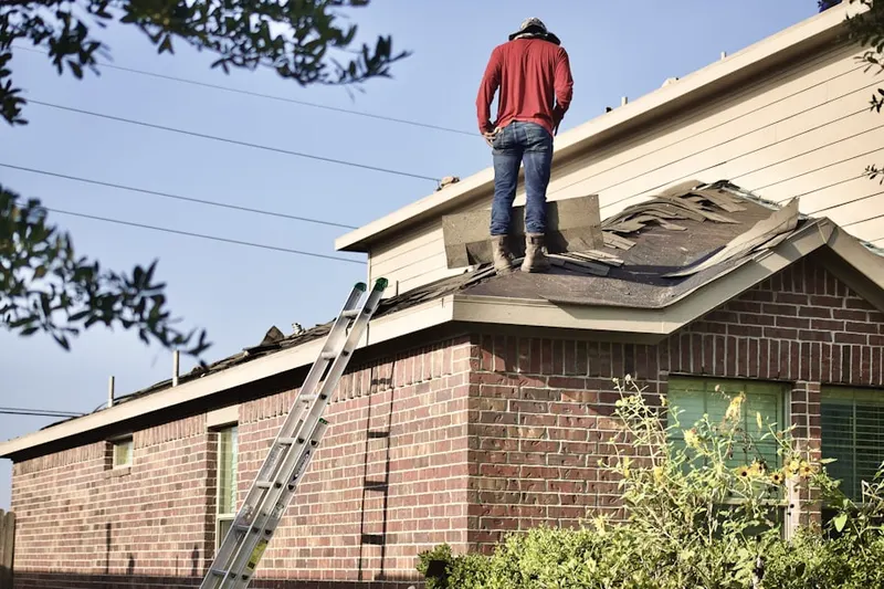 Professional roofer working on a residential roof in Dranesville